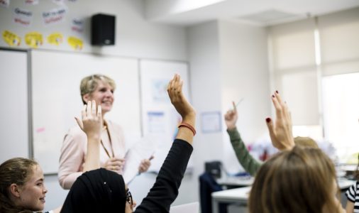 Group of student learning arms raised Second Language Evaluation (SLE)